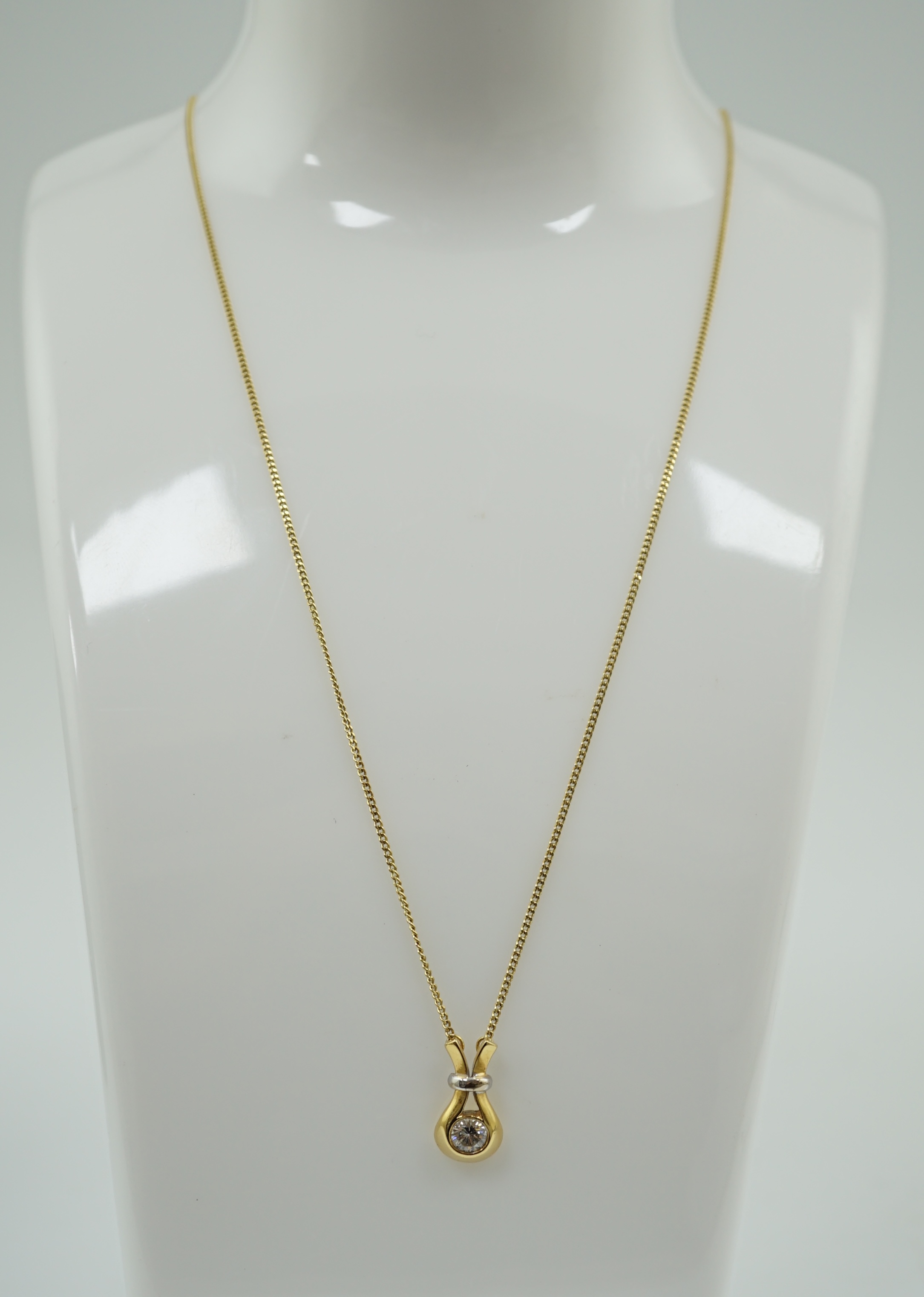 A modern 18ct gold and solitaire diamond set pendant, on an 18ct gold fine link chain